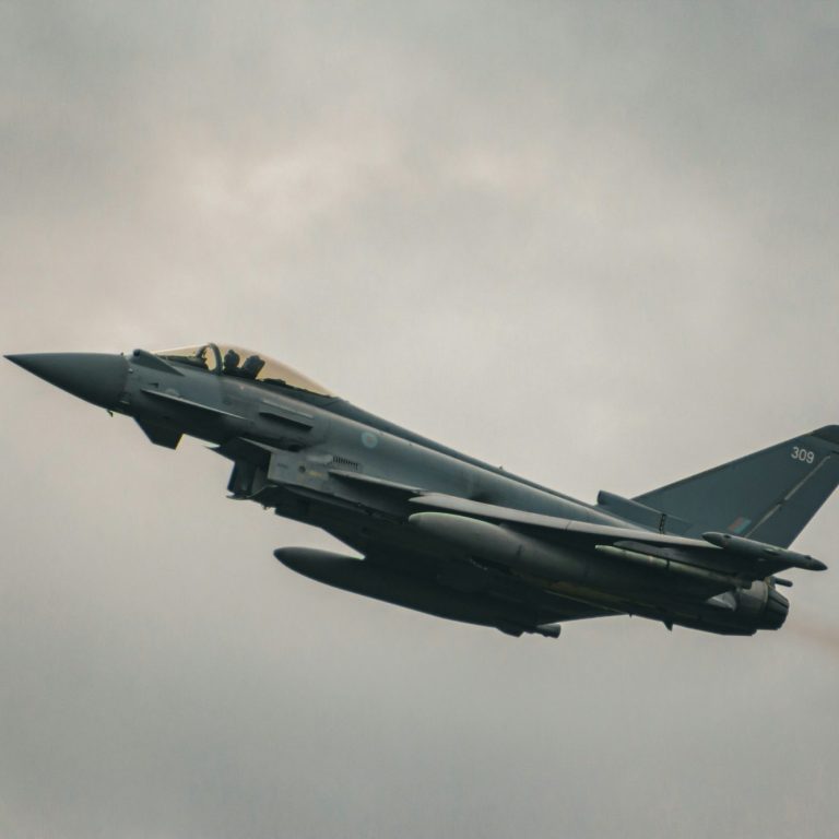 Eurofighter-Jet fliegt mit Wolken im Hintergrund.